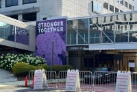 A photograph of a section of the exterior of the Atlanta Medical Center. There is a purple mural that says, "STRONGER TOGETHER."