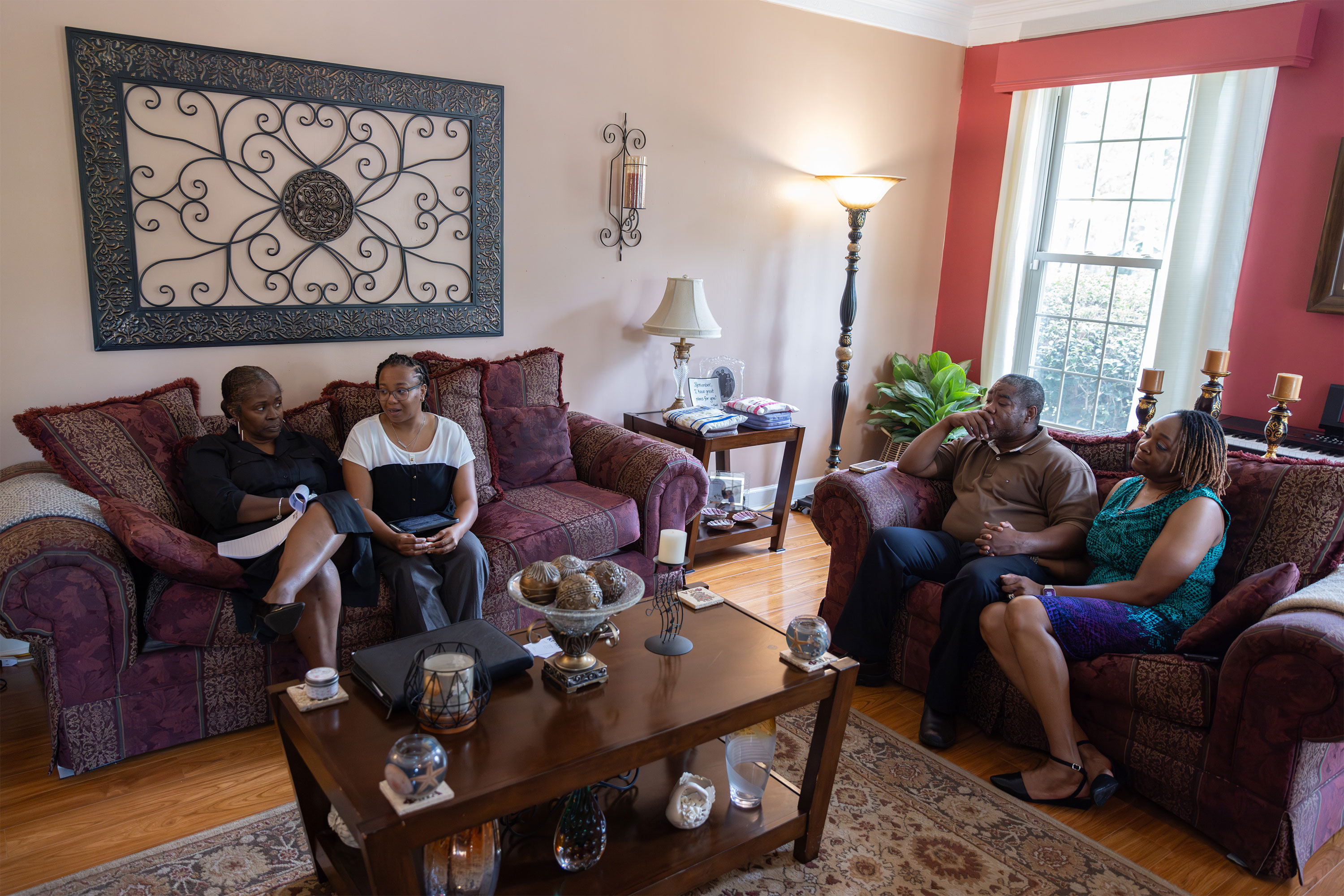 A photo of four people seated in a living room.