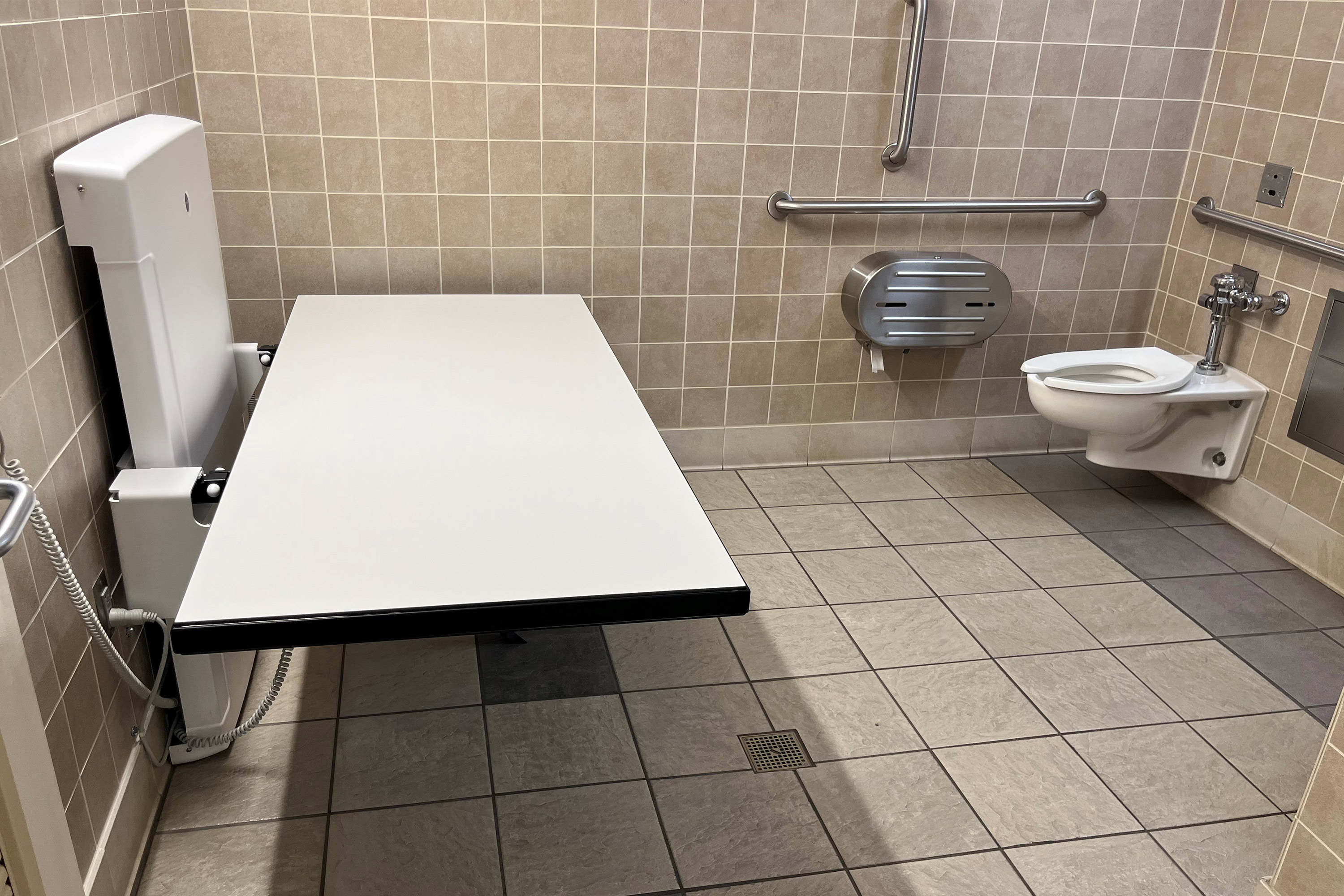 A photo of an adult-size changing table folded down.