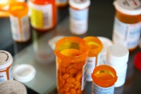 A photo of opened orange pill bottles arranged on a table.