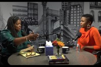 A still from a video of two Black female journalists sitting across from each other, filming a podcast.