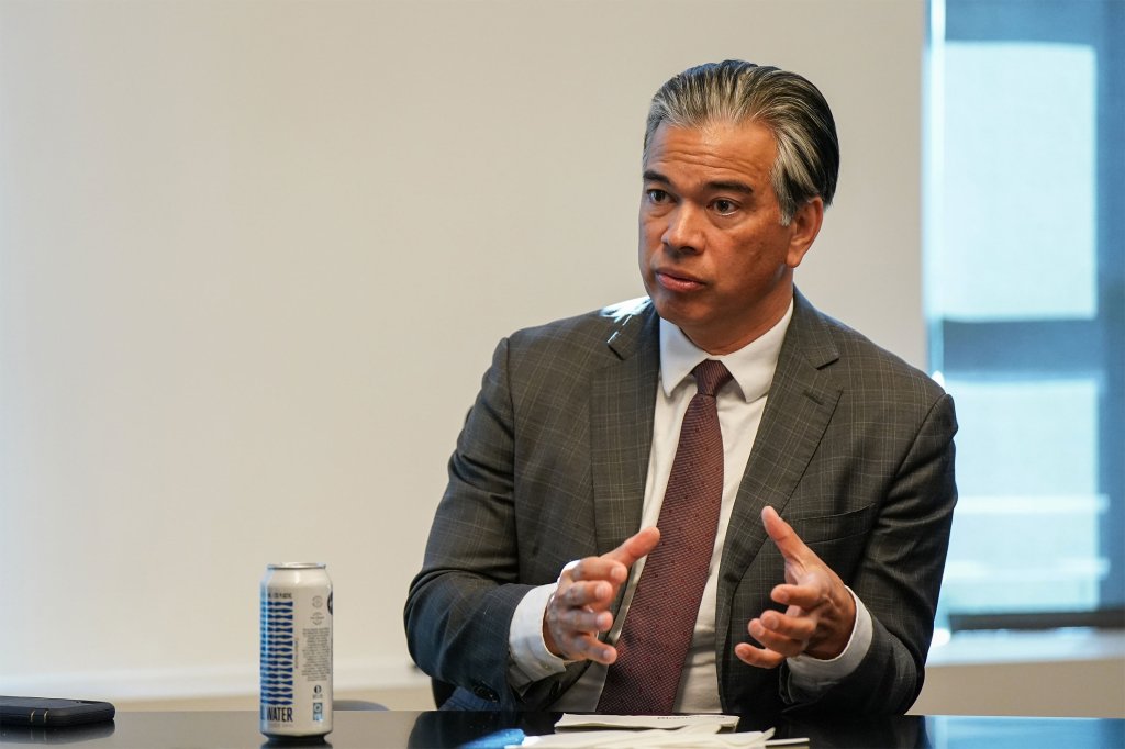 A photo of Rob Bonta gesturing with his hands during an interview.