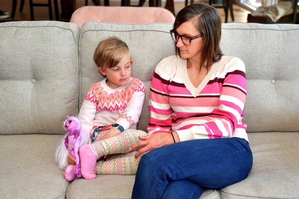 A photo of a mother and daughter sitting together on the sofa.