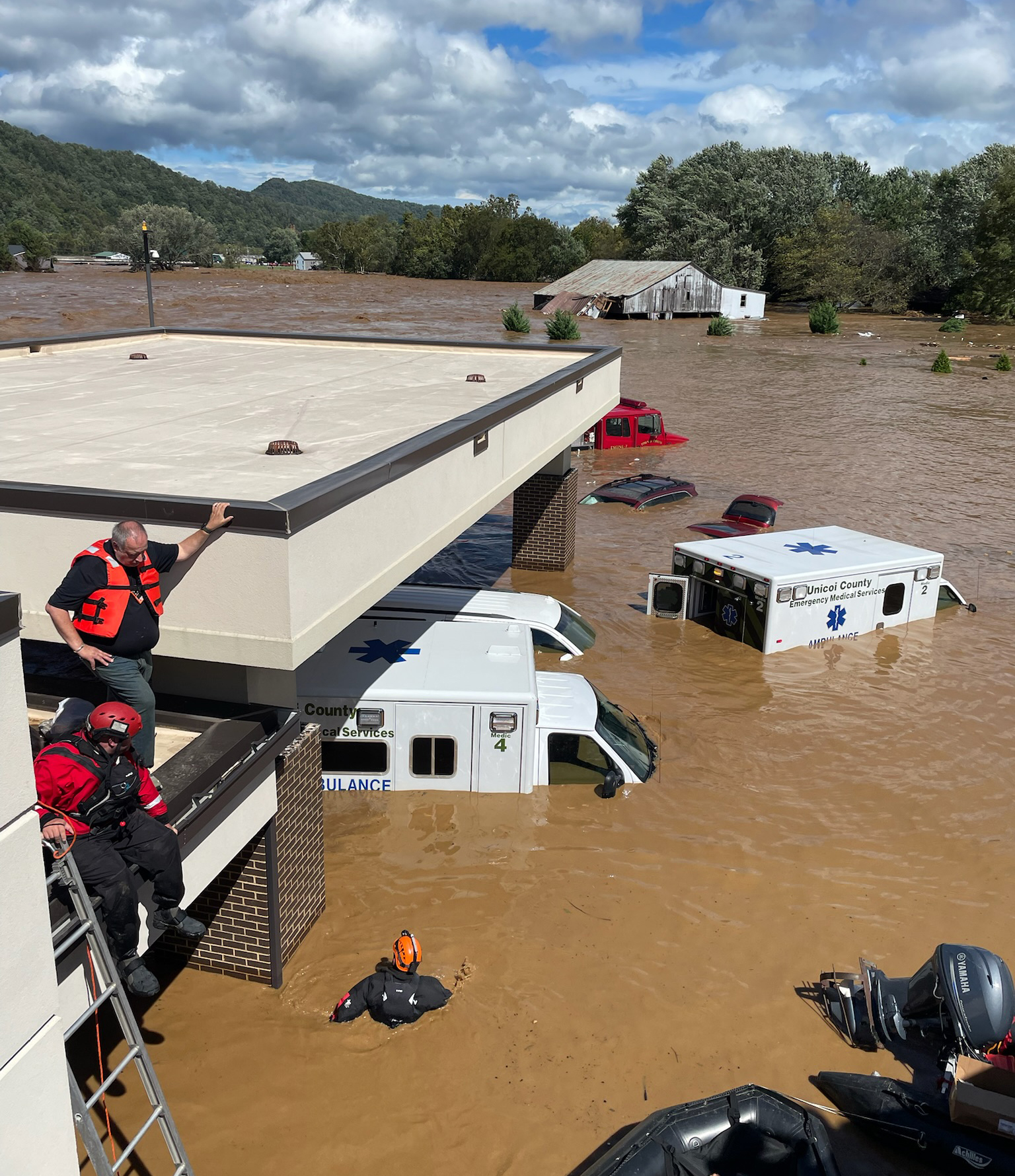 A photo of brown flood waters swallowing up ambulances.