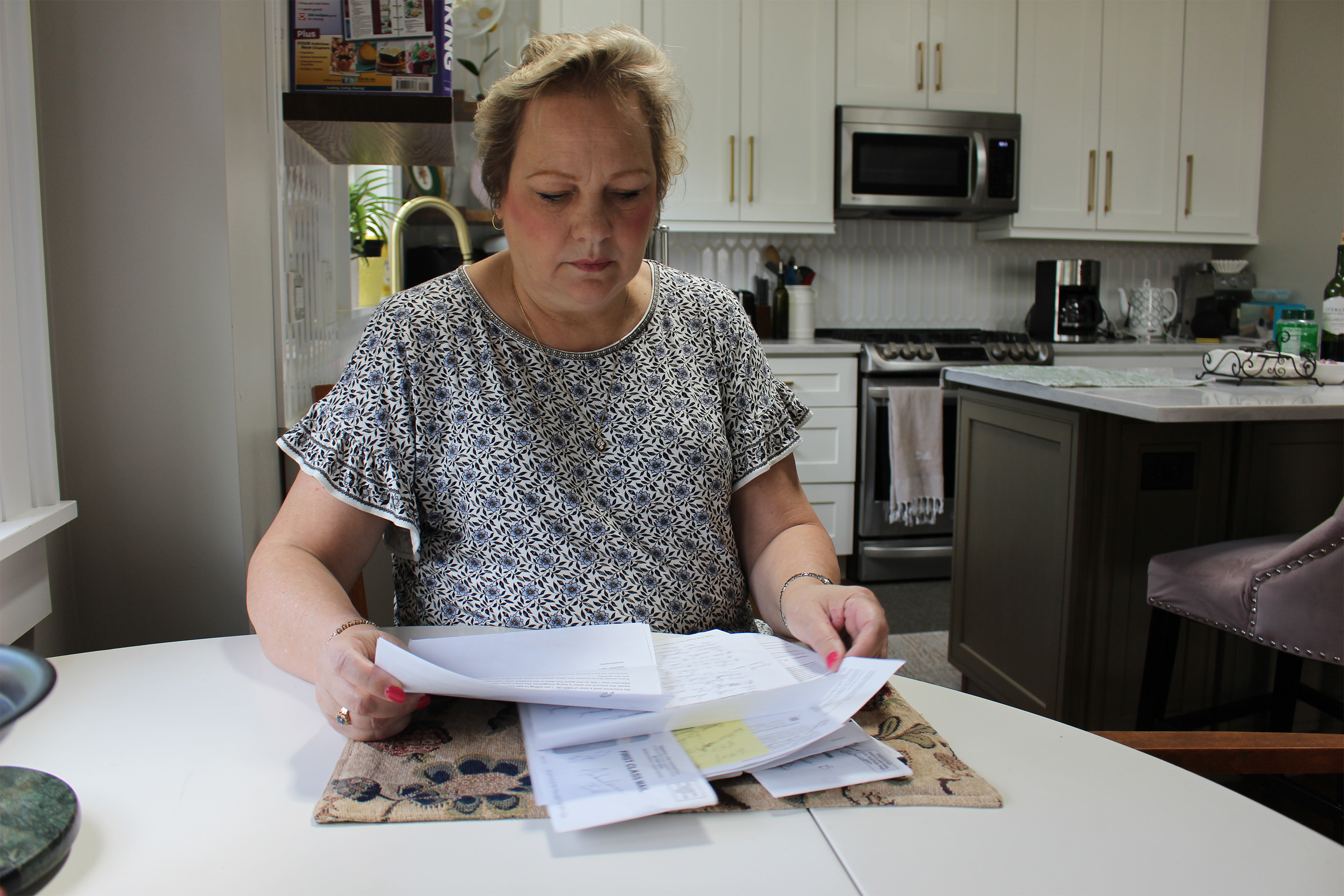 A photo of Peggy Dula reading medical bills.