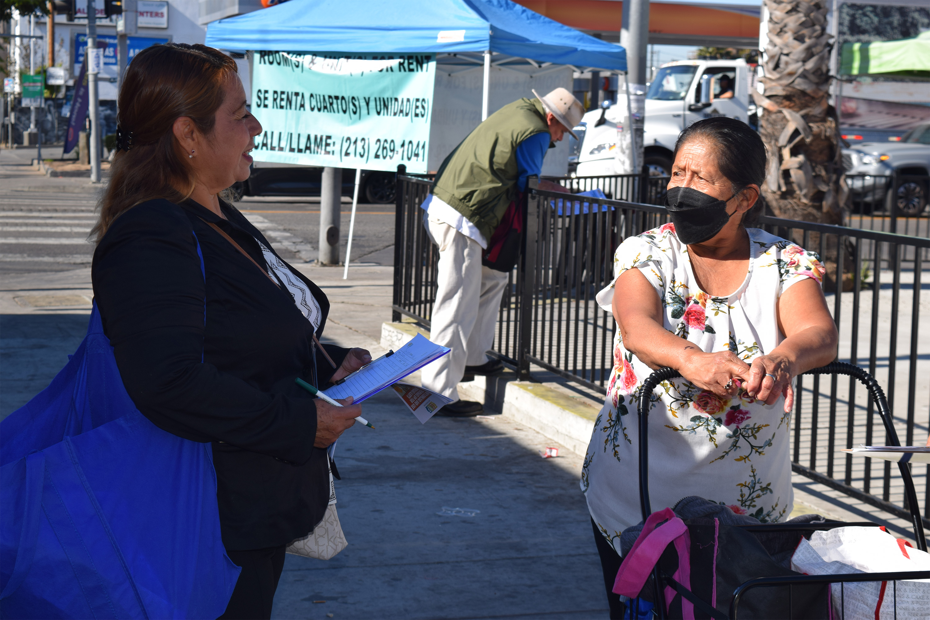 A photo of Yanet Martinez speaking to a woman on the street.