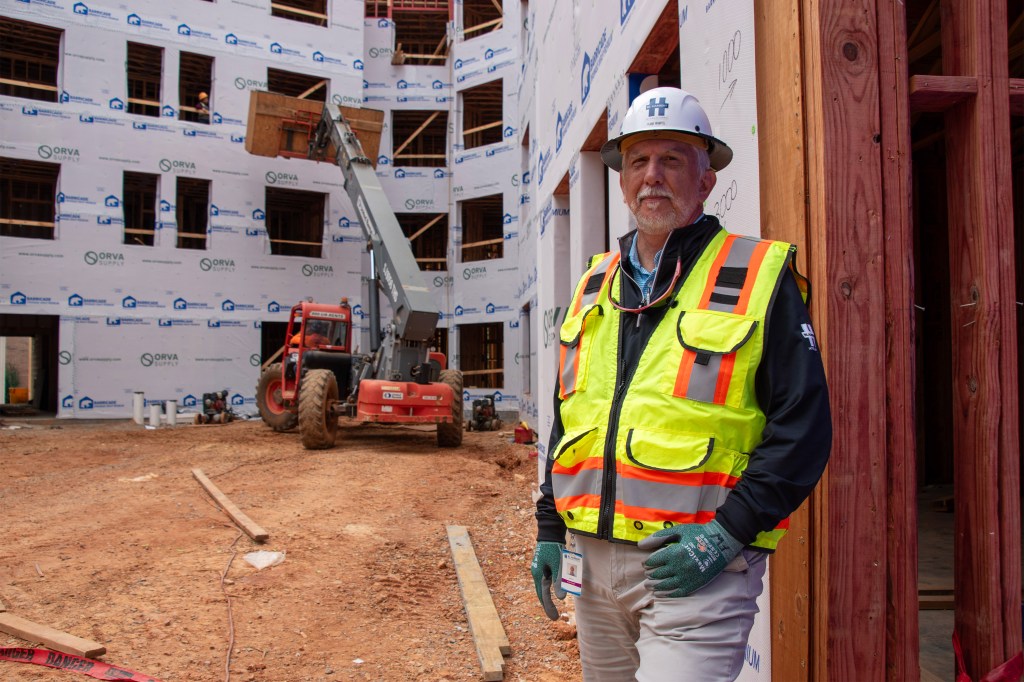 A photo of a construction worker posing for a photo at a construction site.