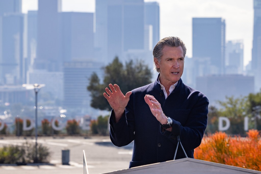 A photo of Gavin Newsom speaking at a press conference outside.