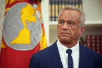 A photo of Robert F. Kennedy Jr. in the Oval Office at the White House. A flag is behind him.