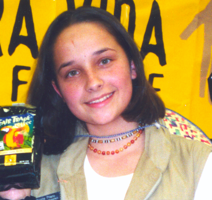 A close-up photo of a smiling 15-year old girl with straight brown hair.