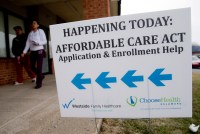 An Affordable Care Act application and enrollment help sign outside of a building.