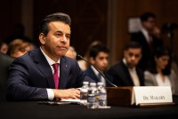 A photo of Marty Makary seated at a desk in a Senate hearing room with a microphone in front of him. His hands are folded in front of him.