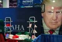 A photo of a merch counter with baseball caps and beanies in various colors bearing the "Make America Healthy Again" slogan.
