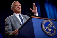 A photo of Robert F. Kennedy Jr. speaking at a podium with the Health and Human Services logo on it.