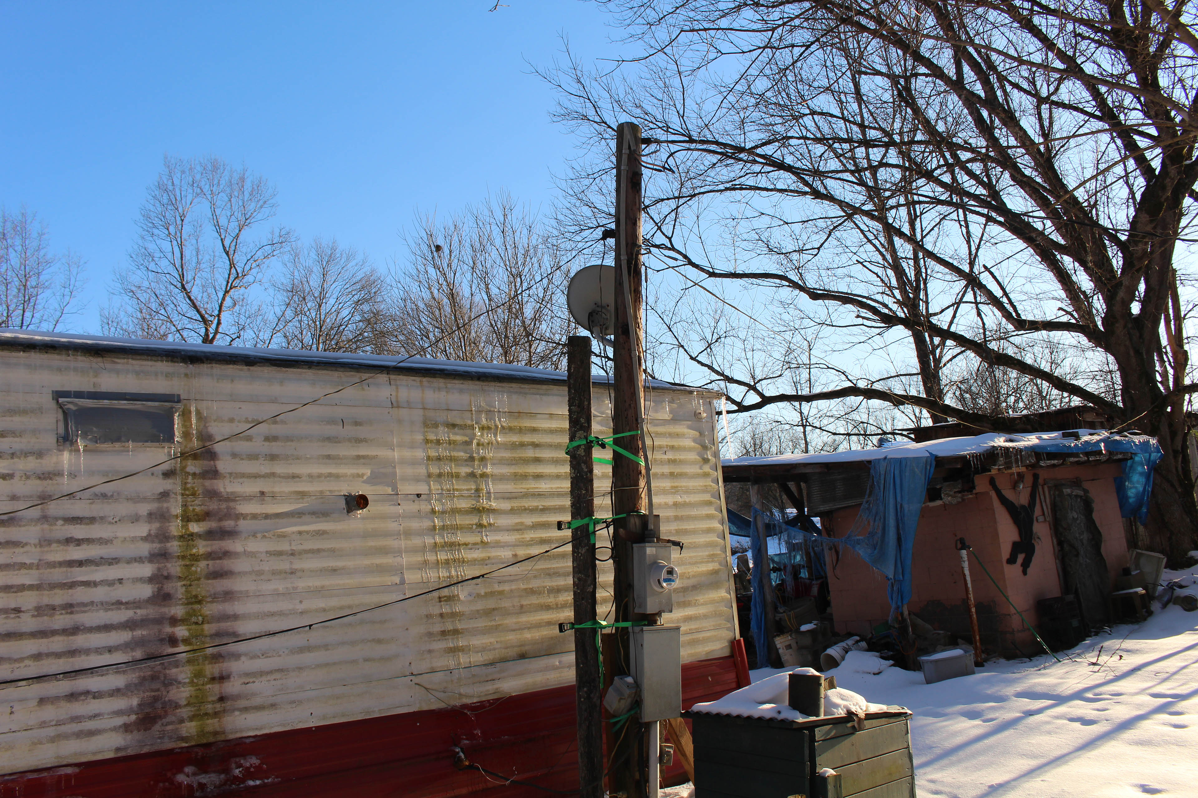 Two poles are shown with green ties and wires outside a trailer