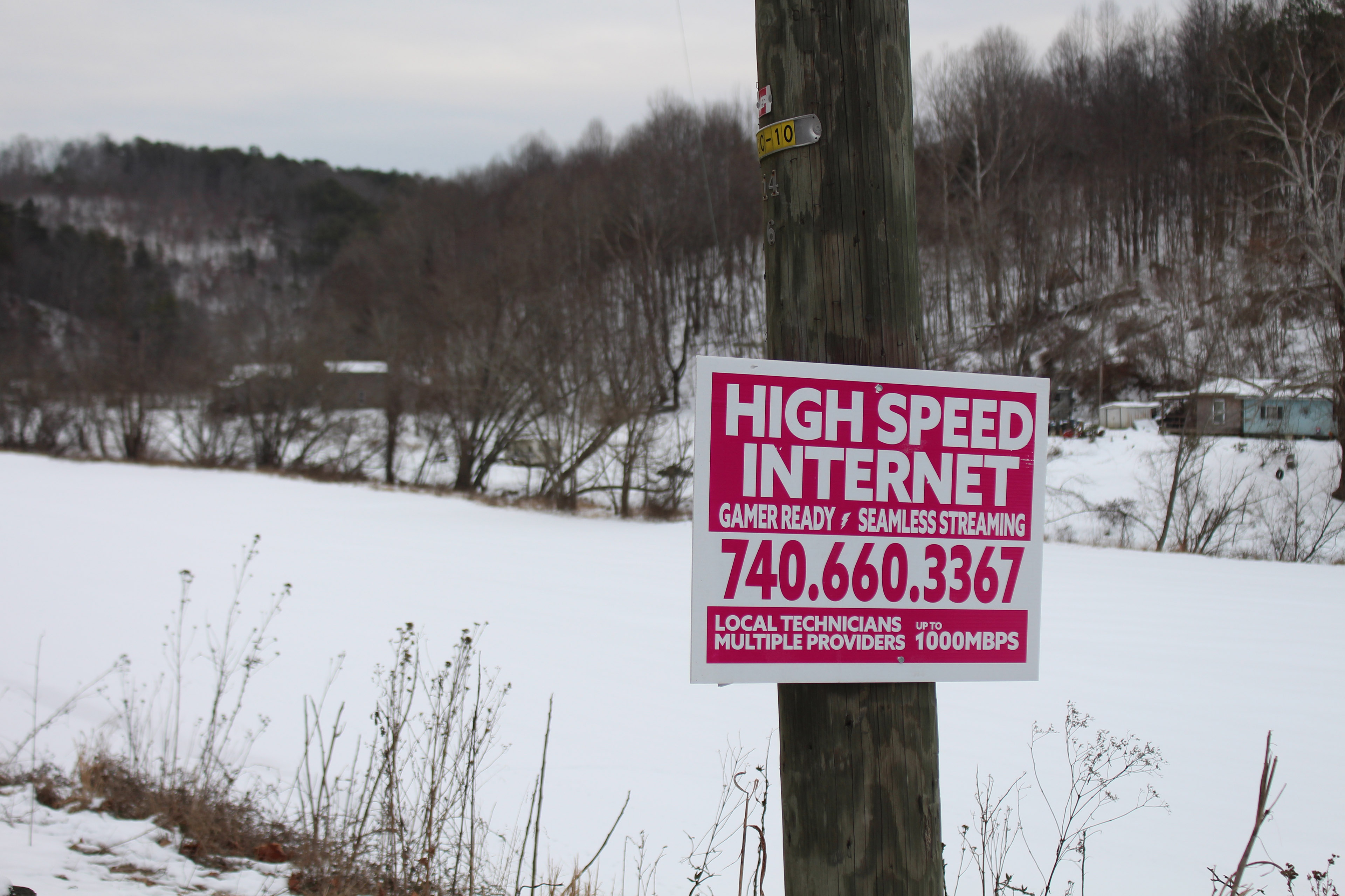 A red and white sign attached to a telephone pole advertises "high speed internet"