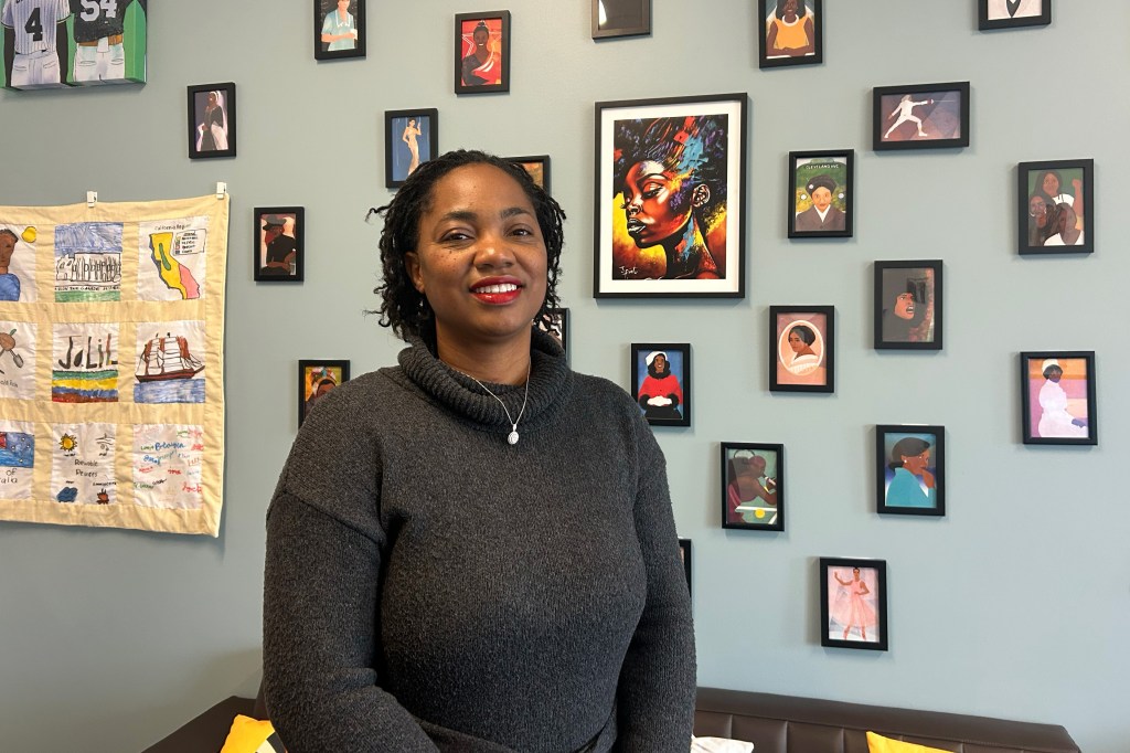 A photo of California state Senator Akilah Weber Pierson indoors. Behind her is a wall covered in colorful art prints.