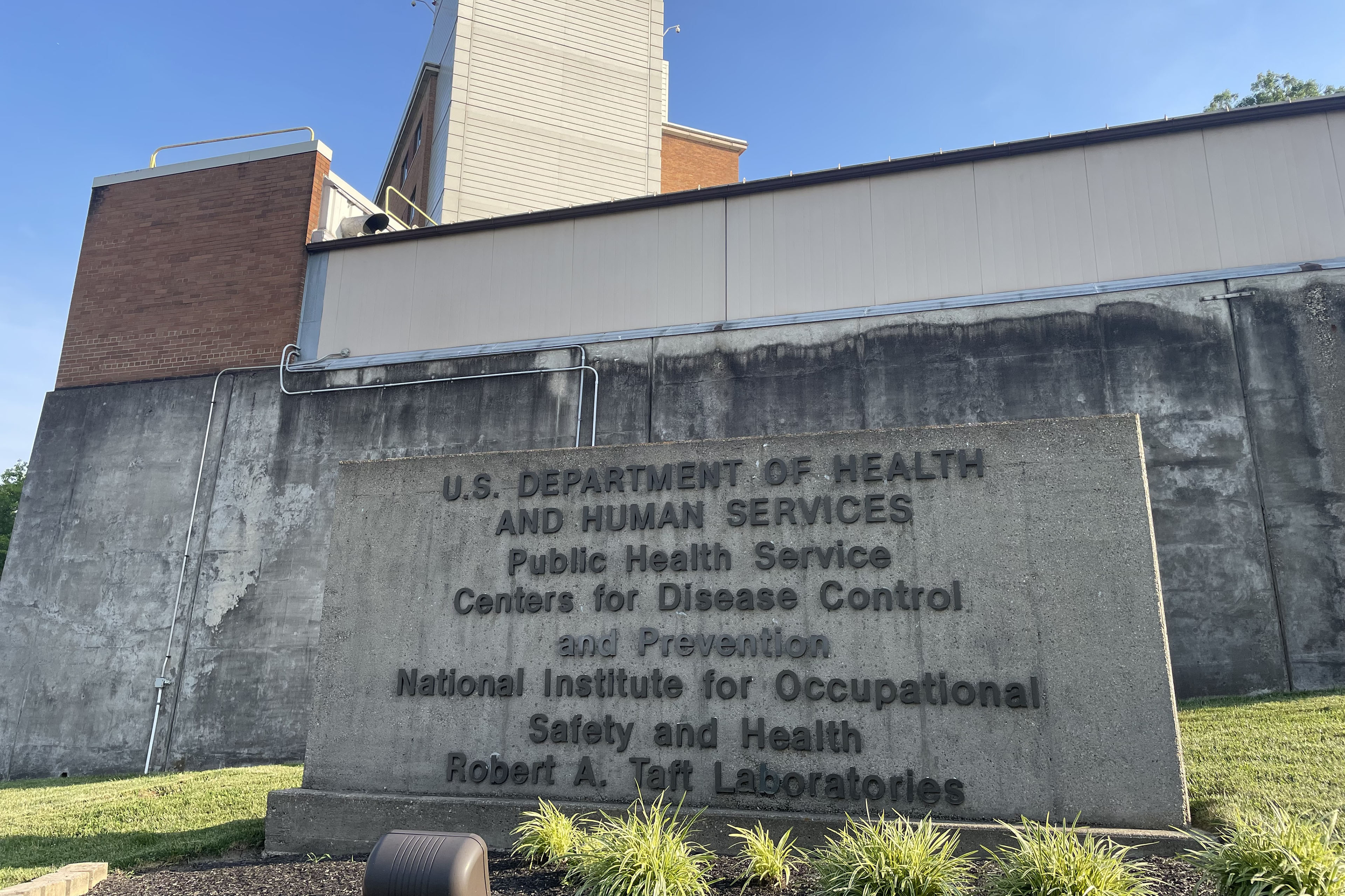 A photo of the exterior of a cement building. A large cement sign reads: "U.S. Department of Health and Human Services / Public Health Service / Centers for Disease Control and Prevention / National Institute for Occupational Safety and Health / Robert A. Taft Laboratories."