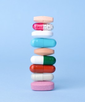 An up-close artistic photo of a stack of different multi-colored pills.