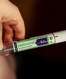 A photo of someone using a Zepbound injector pen on their stomach.